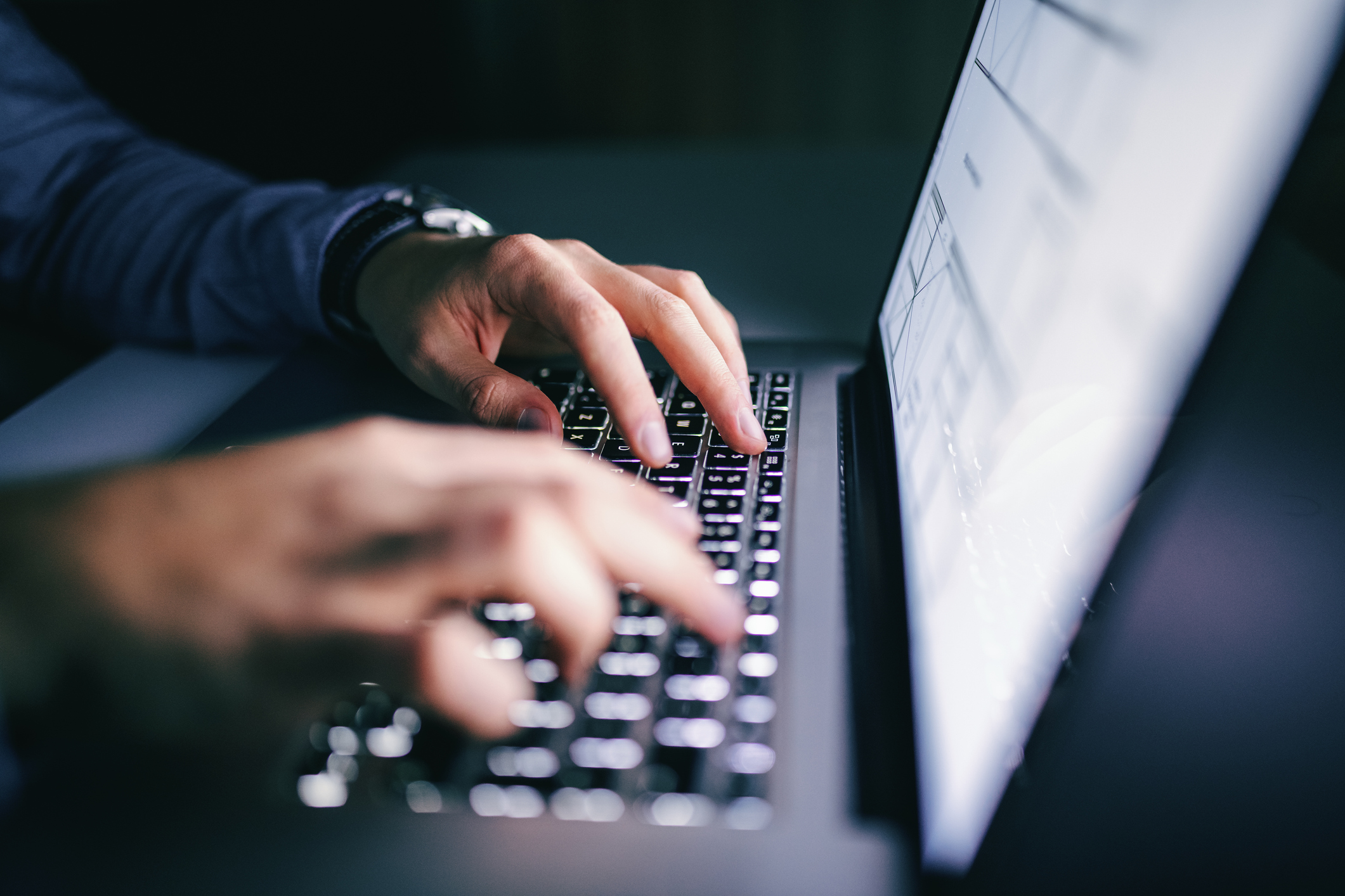 Close up of hands typing on laptop. Night work concept. GettyImages 1091348950